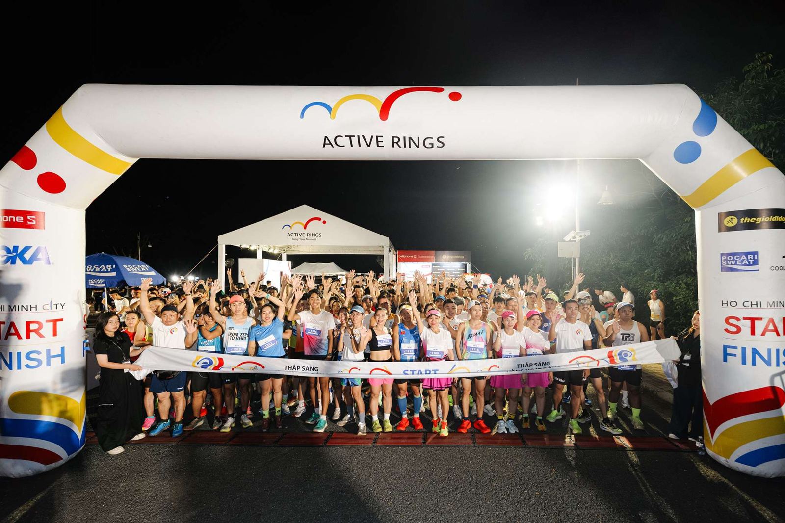 Runners under the Active Rings gate at night