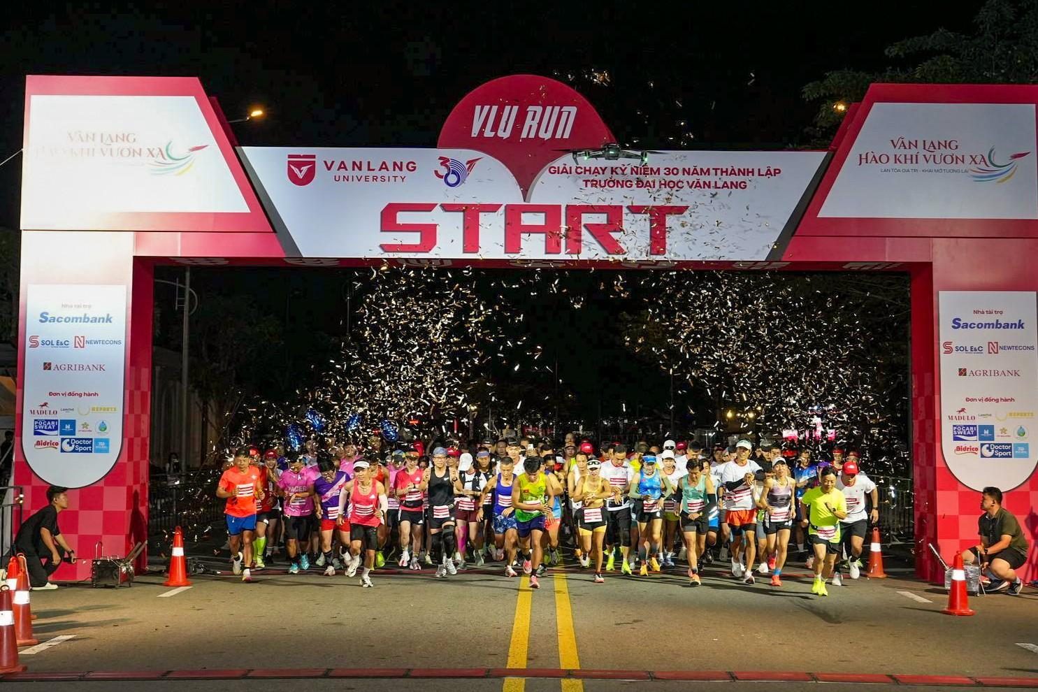 Runners starting under the START gate in a shower of confetti at VLU RUN 2025
